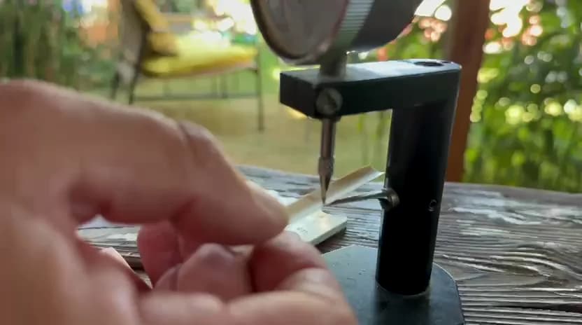 Maker measuring the thickness of gouged oboe cane with a dial gauge