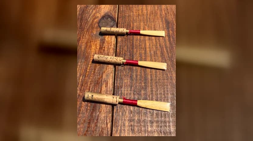 Three finished handmade oboe reeds tied with red thread